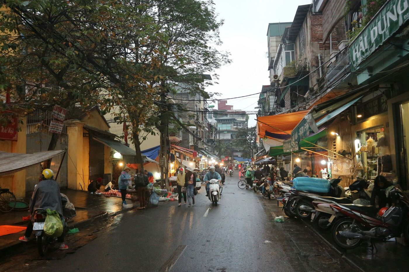 Motorräder und Geschäfte in einer Straße in Hanoi