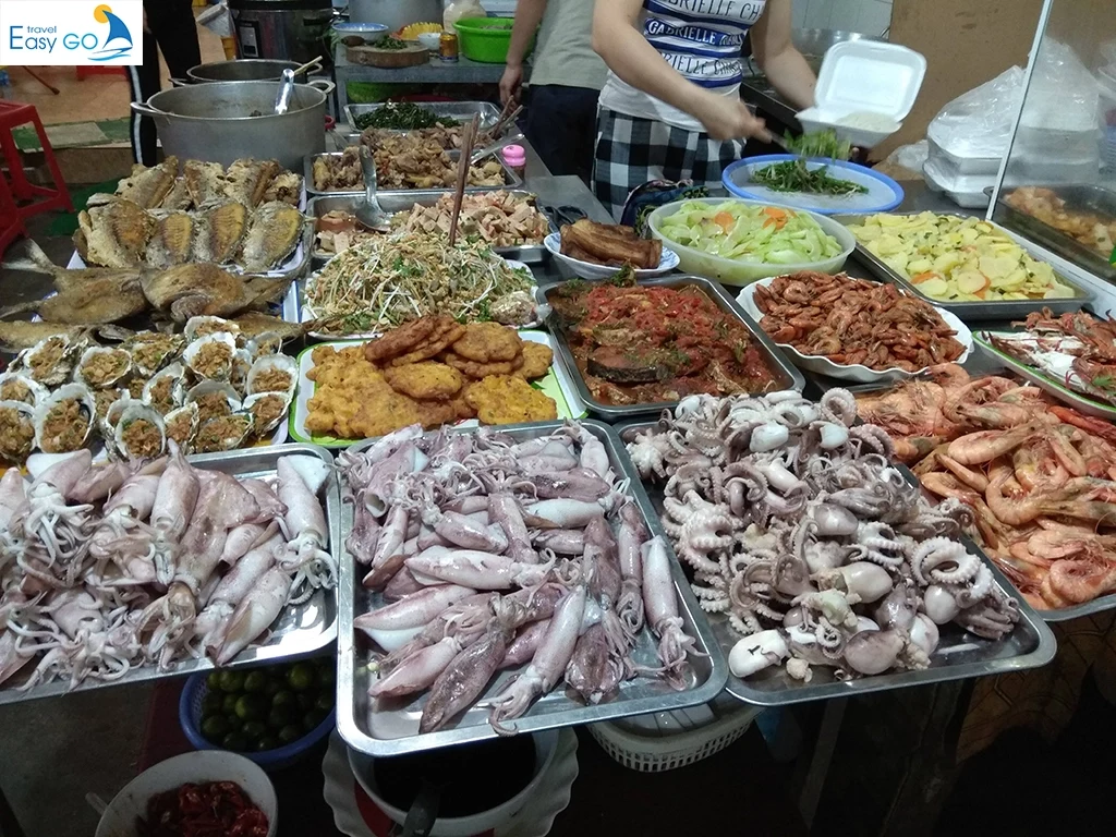 Seafood dishes and ingredients displayed at a Cat Ba market stall