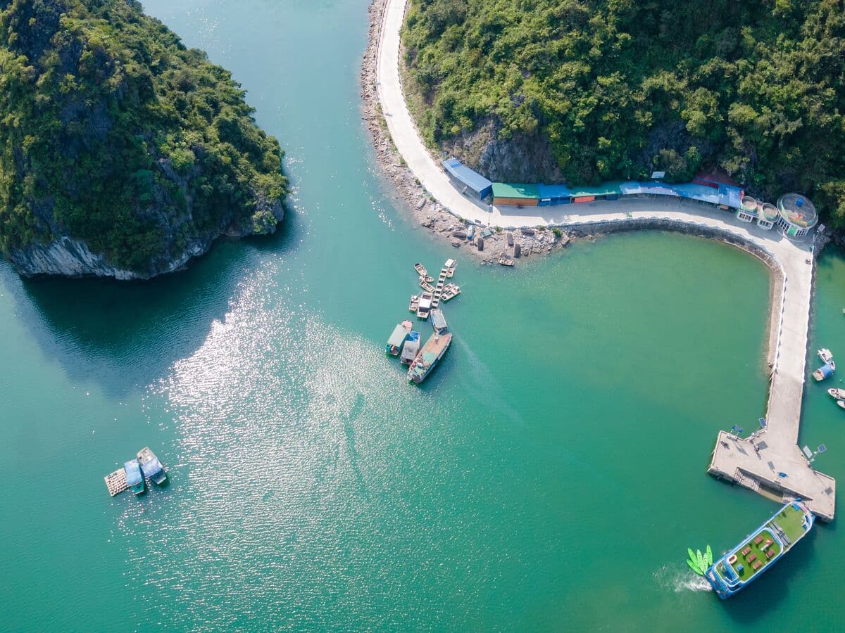 Aerial view of Viet Hai pier surrounded by limestone karsts and emerald water