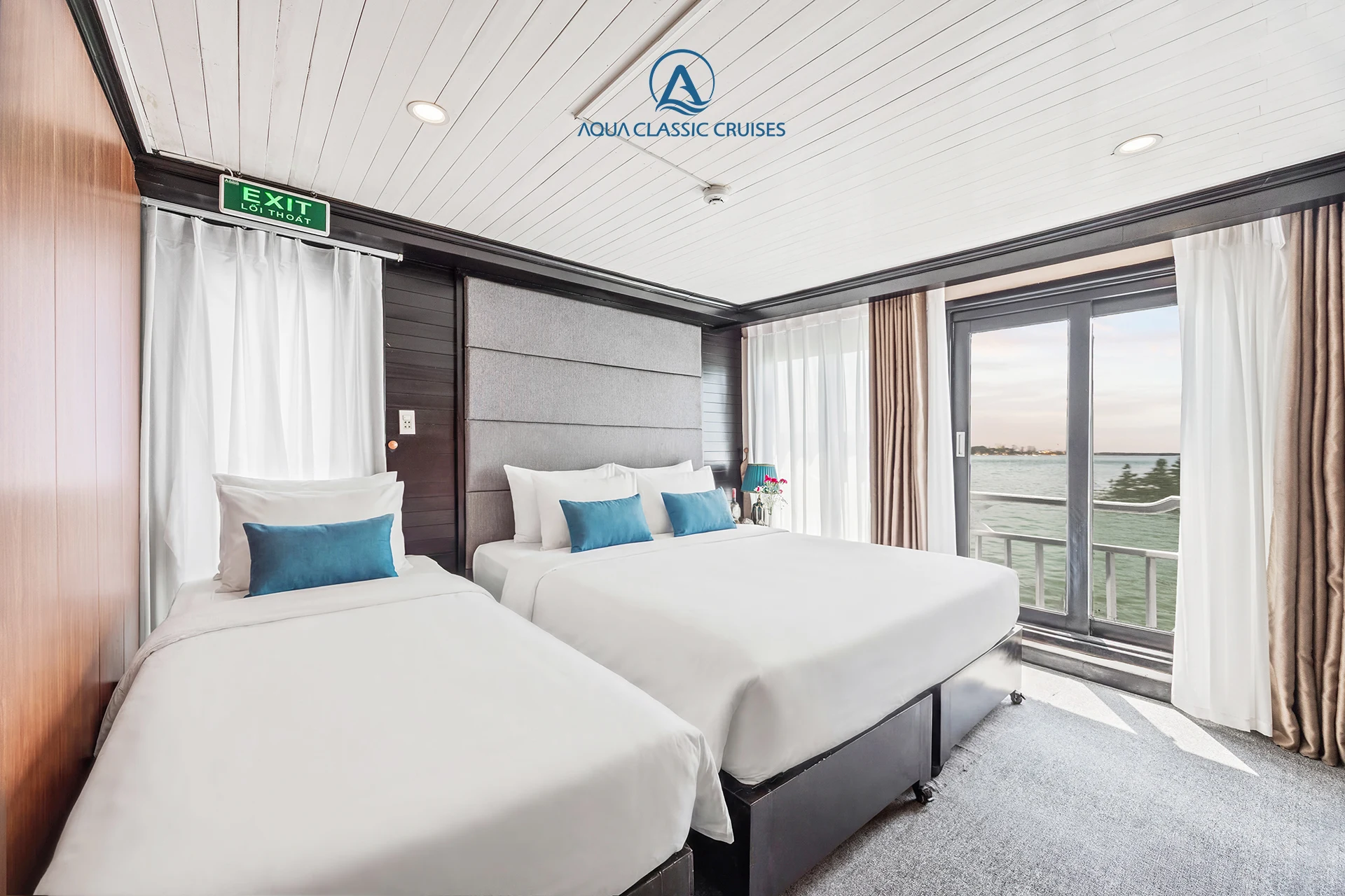 Suite Cabin with a double bed, a single bed and glass doors to the balcony on Aqua Classic Cruise