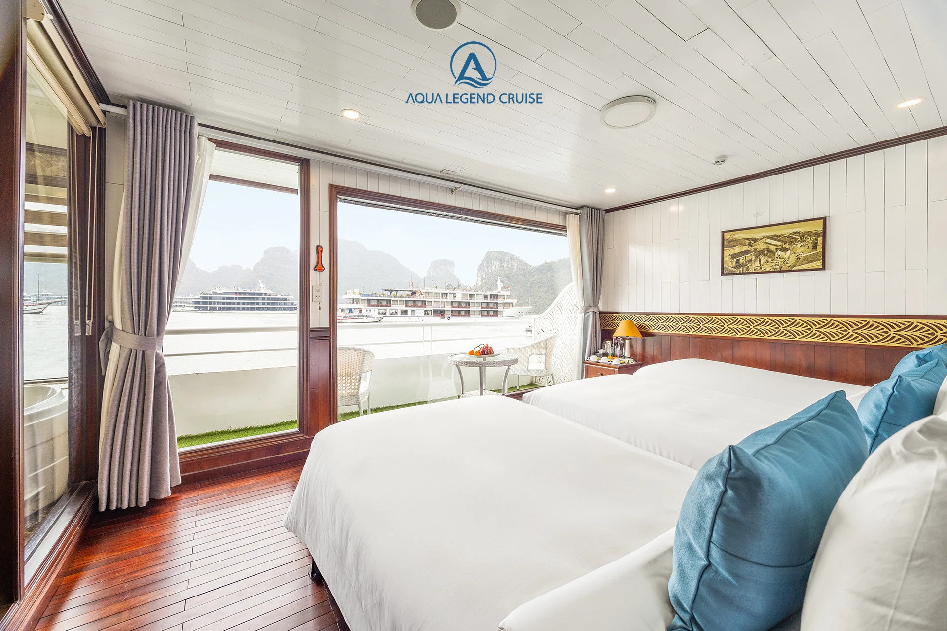 Triple Suite Balcony cabin with two beds beside a glass door onto the balcony on Aqua Legend Cruise