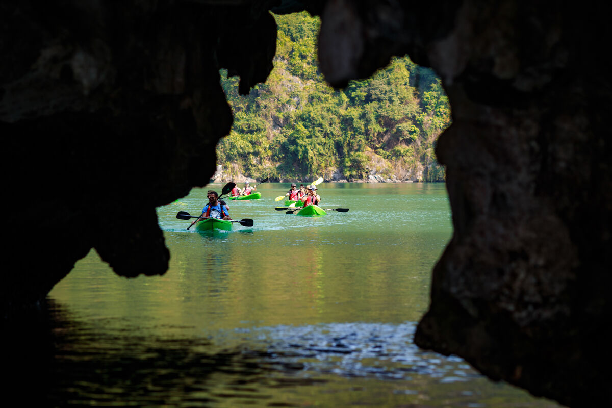 Kayakers between limestone cliffs in Lan Ha Bay